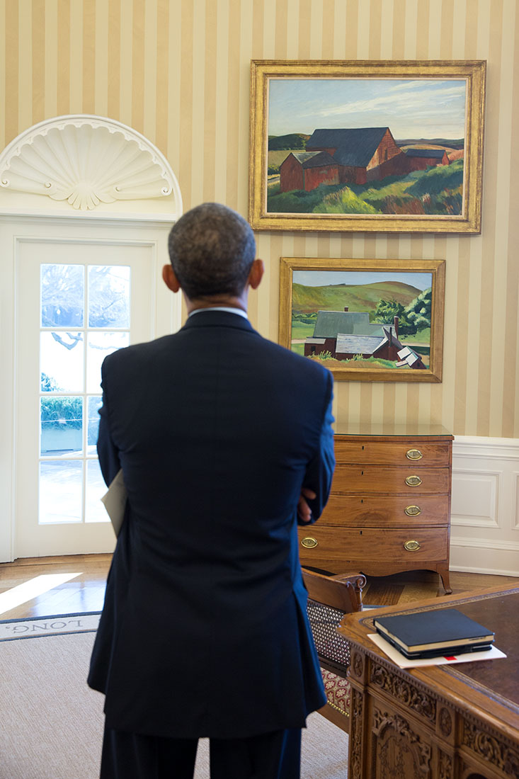 President Barack Obama looks at the Edward Hopper paintings displayed in the Oval Office